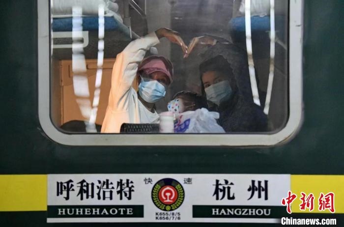 圖為登上轉(zhuǎn)運(yùn)火車的游客向額濟(jì)納比心?！⊥趵?攝