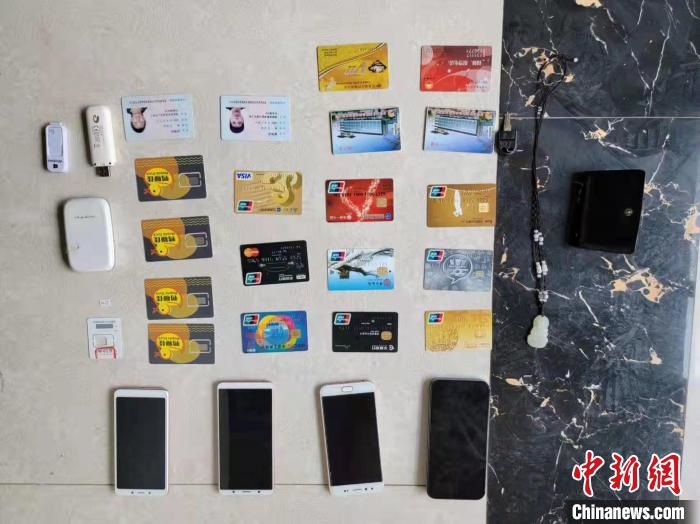 資料圖為果洛藏族自治州公安民警查扣的作案手機(jī)和涉案銀行卡?！‖斍呖h公安局供圖