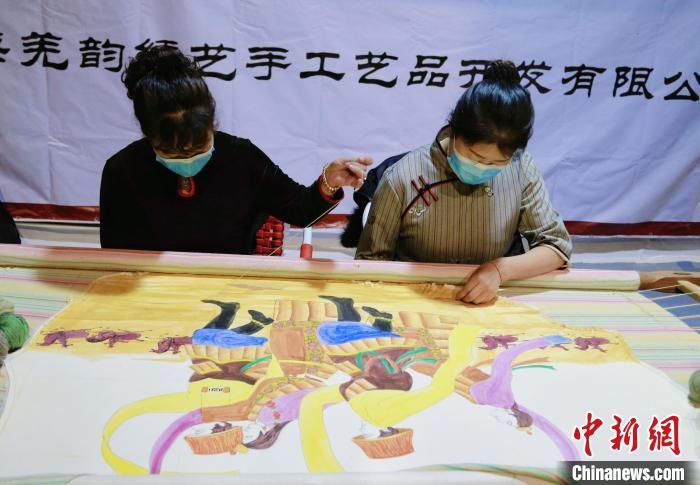 圖為皮繡藝人在市集上“秀”指尖技藝?！●R銘言 攝