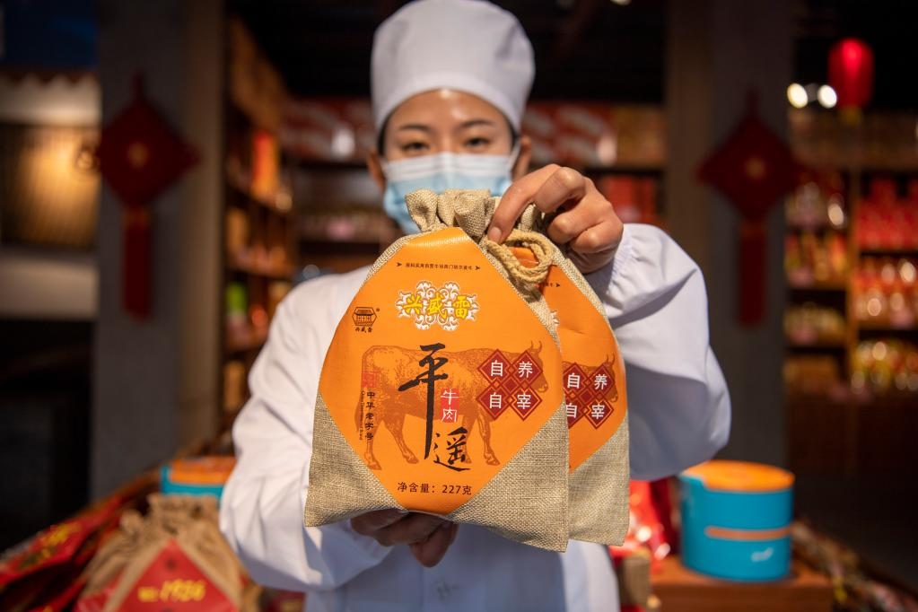 1月27日，在平遙古城南大街的一家平遙牛肉店內(nèi)，工作人員展示一款牛肉產(chǎn)品。新華社記者 楊晨光 攝