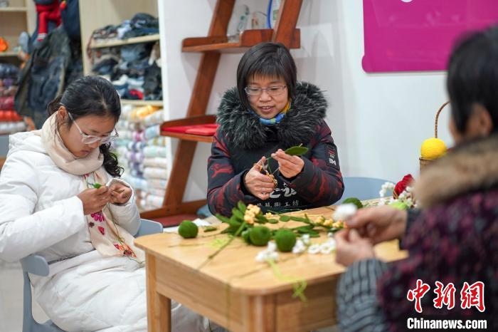 文創(chuàng)工作室的姐妹們正在鉤織月桂葉片。　古良駒 攝