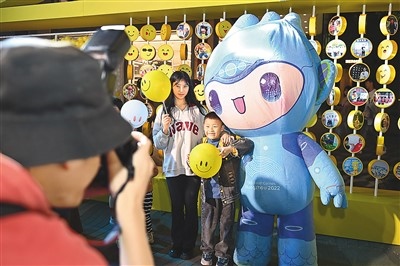 5月7日，在浙江省杭州市湖濱步行街“3D笑臉墻”前，攝影師為游客與杭州亞運(yùn)會(huì)吉祥物之一“宸宸”拍攝合影。