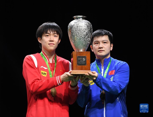 5月27日，樊振東（右）/王楚欽在頒獎儀式上高舉獎杯慶祝。當(dāng)日，在南非德班進(jìn)行的2023年世界乒乓球錦標(biāo)賽男雙決賽中，中國組合樊振東/王楚欽以3比0戰(zhàn)勝韓國組合張禹珍/林鐘勛，奪得冠軍。新華社記者 李亞輝攝