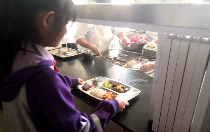 伊金霍洛旗第一小學(xué)學(xué)生正在打飯，今天的飯菜是三菜一湯外加水果，學(xué)生可以多次盛取，吃飽為止。人民網(wǎng)記者 孫博洋攝