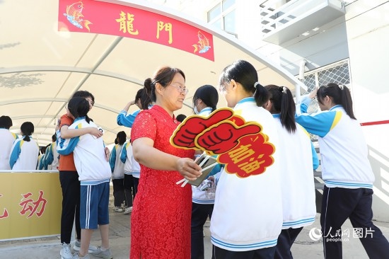6月7日一早，雄安新區(qū)安新中學(xué)老師在給同學(xué)們加油鼓勁兒。人民網(wǎng) 李兆民攝