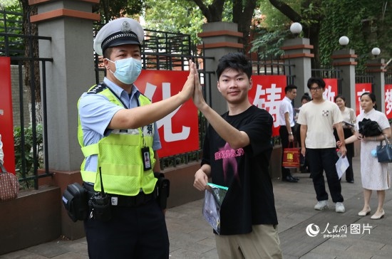 6月7日8時許，武漢中學(xué)考點門口，交警在維護(hù)秩序，并祝考生金榜題名。人民網(wǎng)記者 肖璐欣攝