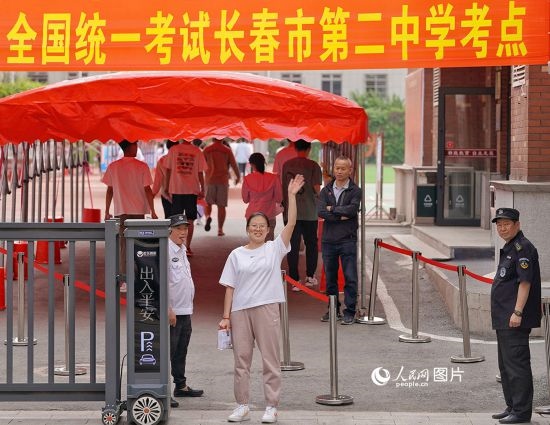 6月7日，在長春市第二中學(xué)考點，一名考生信心滿滿進(jìn)入考場，并與家長揮手致意。人民網(wǎng)記者 李洋攝