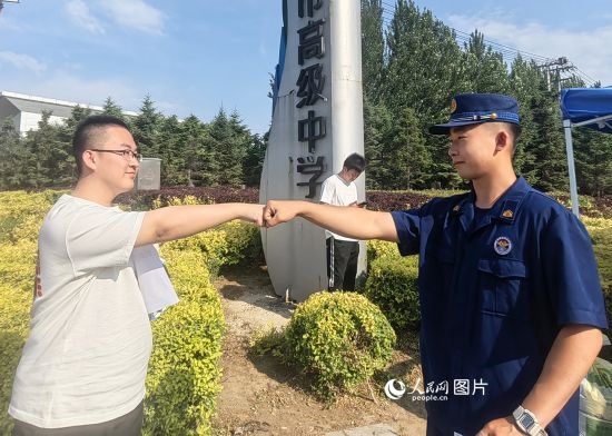 6月7日，遼寧營口老邊區(qū)消防救援大隊的消防員為高考學(xué)子加油助威。人民網(wǎng)記者 尹柏寒?dāng)z