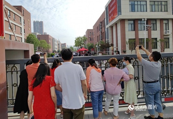 6月7日，武漢市第三中學(xué)考點，考生進(jìn)場后，家長在柵欄外用手機拍攝自己的孩子。人民網(wǎng)記者 郭婷婷攝