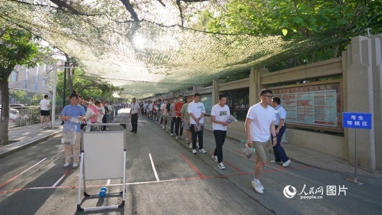 6月7日，烏魯木齊市第七十中學(xué)門口，考生們有序進(jìn)入考場。人民網(wǎng) 李欣洋攝