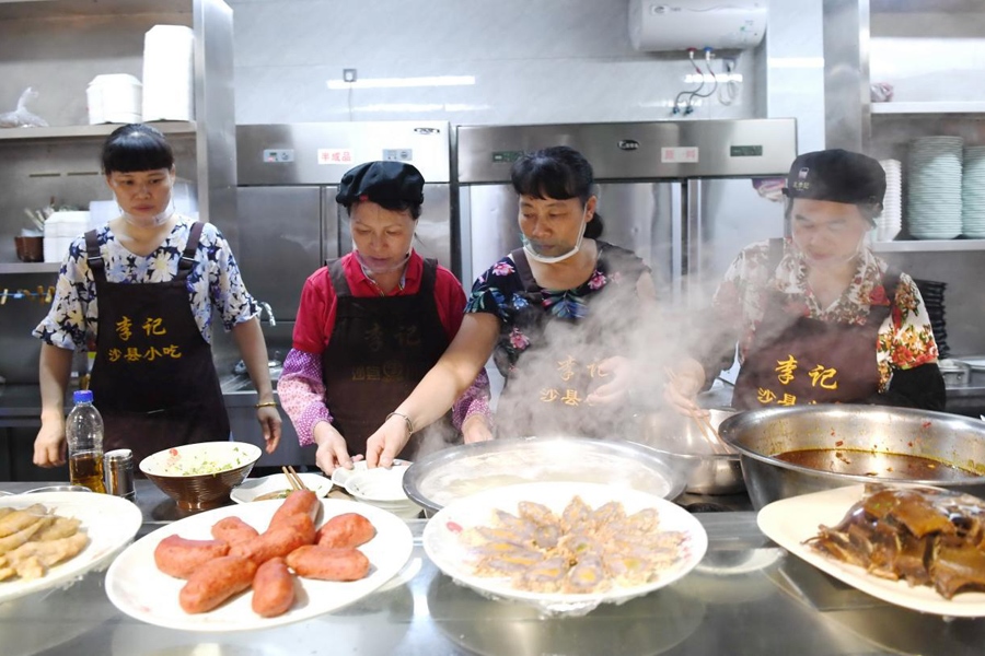 福建三明市沙縣區(qū)一家小吃店工作人員在為客人準(zhǔn)備特色小吃。 新華社記者 林善傳 攝