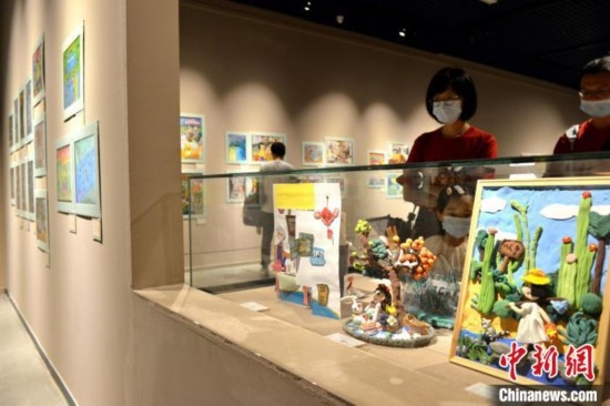 圖為家長(zhǎng)帶著孩子參觀展覽。呂明 攝