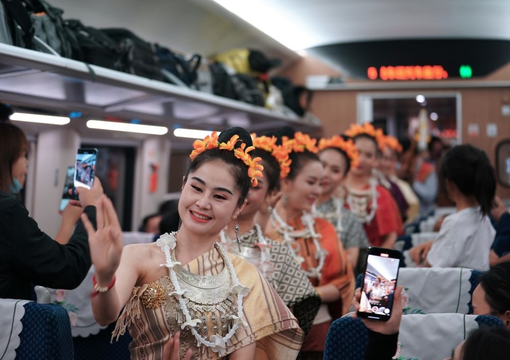 2023年4月13日，老撾工作人員在D887次國際旅客列車上表演。當日，中老鐵路從中國昆明南站、老撾萬象站雙向對開D887次和D888次國際旅客列車，兩地乘火車可當日通達。中老鐵路是高質量共建“一帶一路”的標志性工程。新華社記者 邢廣利 攝