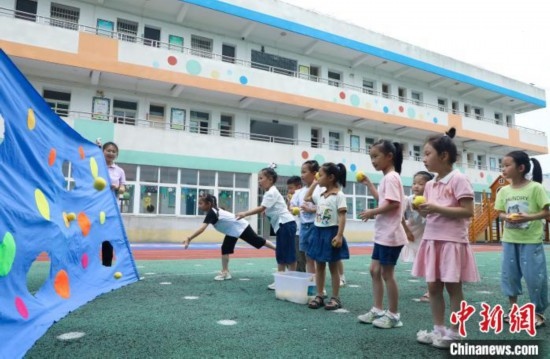 在肥西縣山南鎮(zhèn)中心幼兒園，孩子們在玩布洞投球游戲。陳家樂 攝