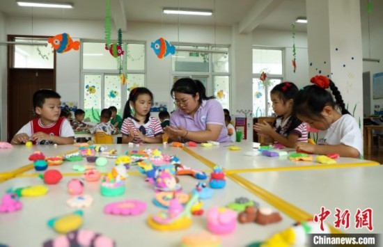 在肥西縣山南鎮(zhèn)中心幼兒園，孩子們在老師的指導下做彩色泥塑。陳家樂 攝