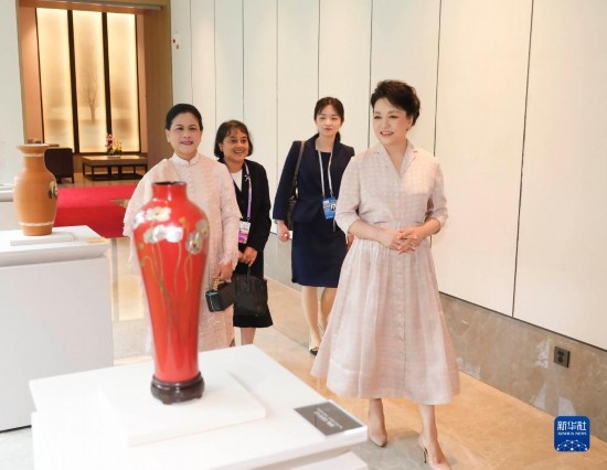 7月27日下午，國(guó)家主席習(xí)近平夫人彭麗媛在四川成都會(huì)見陪同印度尼西亞總統(tǒng)佐科來華出席第31屆世界大學(xué)生夏季運(yùn)動(dòng)會(huì)開幕式并訪華的總統(tǒng)夫人伊莉亞娜。這是彭麗媛和伊莉亞娜欣賞成都特色非遺工藝品。新華社記者 丁林 攝