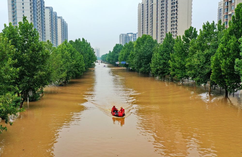 救援人員在河北省涿州市市區(qū)乘坐沖鋒舟前去轉(zhuǎn)移受災(zāi)群眾（8月2日攝，無人機(jī)照片）。新華社記者 牟宇 攝