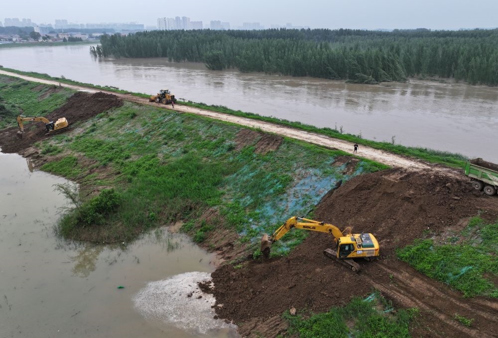 工人操作機(jī)械在白溝河左堤白溝新城高橋村段進(jìn)行除險加固作業(yè)（8月4日攝，無人機(jī)照片）。新華社記者 朱旭東 攝