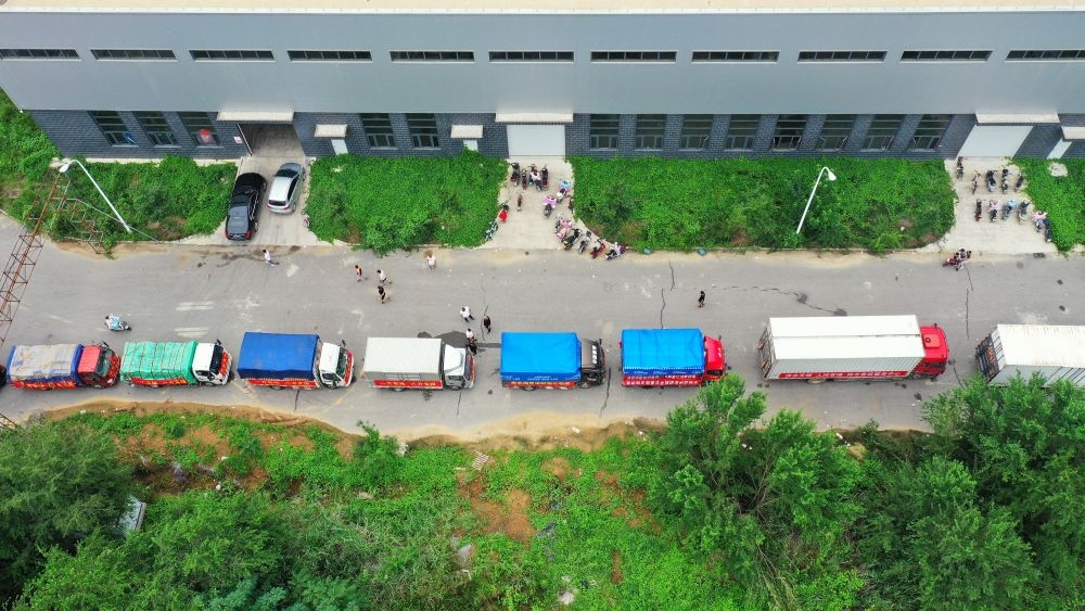 在河北省涿州市鋼研物資儲備點(diǎn)外，運(yùn)送物資的車輛排起長隊(duì)（8月5日攝，無人機(jī)照片）。新華社記者 牟宇 攝