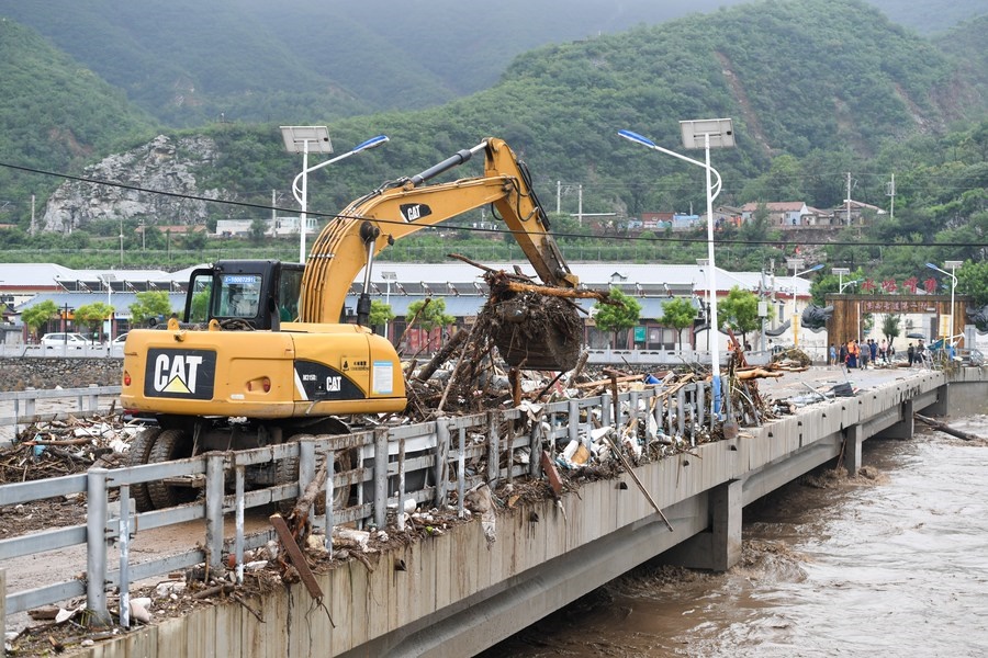 8月1日，在北京市門頭溝區(qū)水峪嘴村村口，一臺挖掘機在清理阻斷橋梁交通的雜物。目前該條道路已經疏通完成。新華社記者 鞠煥宗 攝