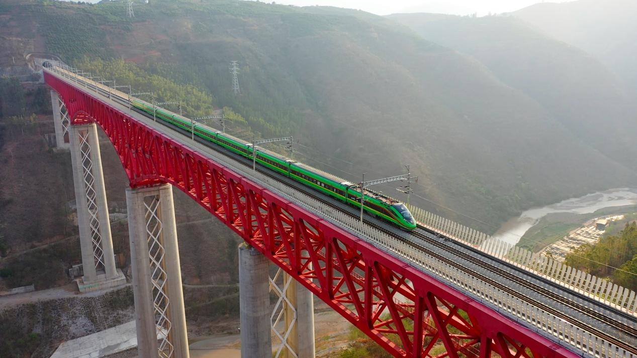 中老鐵路國(guó)際旅客列車在云南省境內(nèi)的元江特大橋上飛馳。姚巍攝