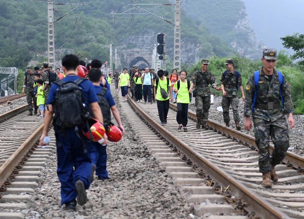 8月2日，部分滯留在北京市門頭溝山區(qū)受困列車的旅客，在救援人員幫助下前往轉(zhuǎn)運客車。新華社記者張晨霖 攝