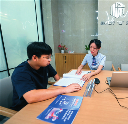 在杭州市臨安區(qū)政務(wù)服務(wù)中心的“為企服務(wù)中心”，黨員志愿者（右）解答企業(yè)主的疑問（2023年7月7日攝）。徐昱攝/本刊