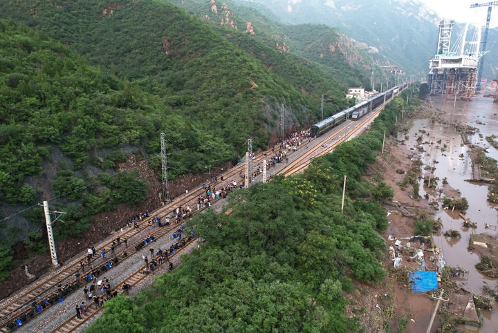 8月2日，受困列車旅客在救援人員幫助下徒步趕往轉(zhuǎn)運(yùn)客車（無人機(jī)照片）。新華社記者 張晨霖 攝