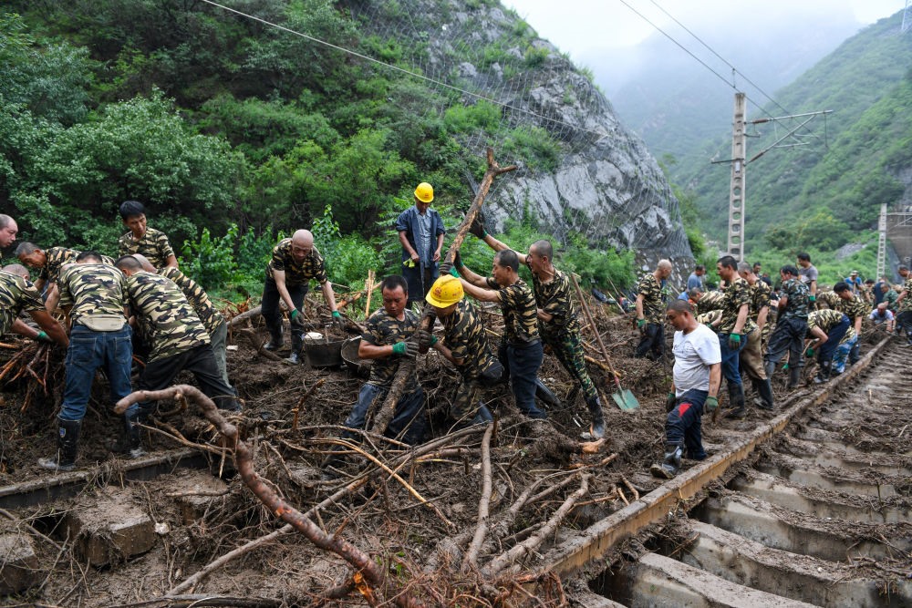 8月1日，在北京市門頭溝區(qū)水峪嘴村附近一段被阻斷的鐵路線上，中鐵六局工作人員在清理軌道上的雜物，全力恢復(fù)交通。新華社記者 鞠煥宗 攝