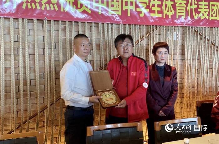 巴西中國和平統(tǒng)一促進會會長王俊曉向中國中學(xué)生體育代表團團長劉立新贈送紀念品。人民網(wǎng)記者 宋亦然攝