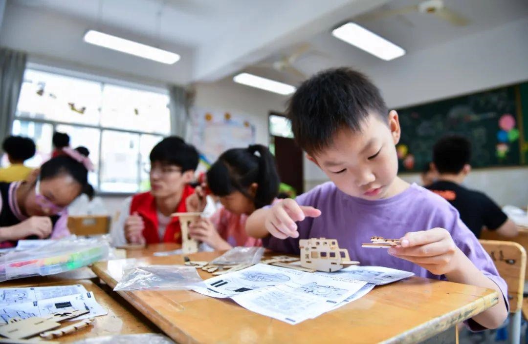 △今年7月，在浙江余姚市舜北小學(xué)暑托班內(nèi)，孩子們制作太陽能科學(xué)實(shí)驗(yàn)裝置。