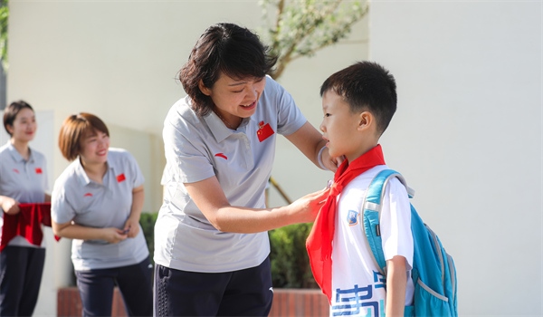 8月30日，雄安史家胡同小學(xué)學(xué)生體驗(yàn)學(xué)校生活。老師為學(xué)生佩戴校徽。