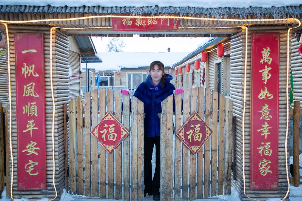 北極村民宿經(jīng)營(yíng)者史瑞娟在門前迎候入住的游客（2023年1月7日攝）。