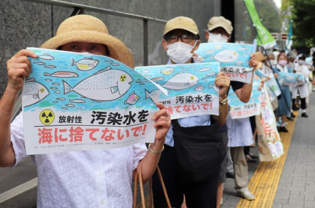 8月24日，日本民眾手持“不要將污染水扔進大?！钡葮苏Z在東京電力公司總部前集會，抗議日本政府和東電公司無視民意啟動核污染水排海。新華社記者楊光攝