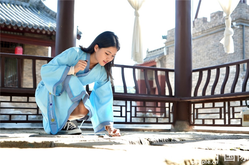 圖為選手在“曲水流觴亭”將“桃心”蠟燭放入渠中。人民網(wǎng) 盧鵬宇攝