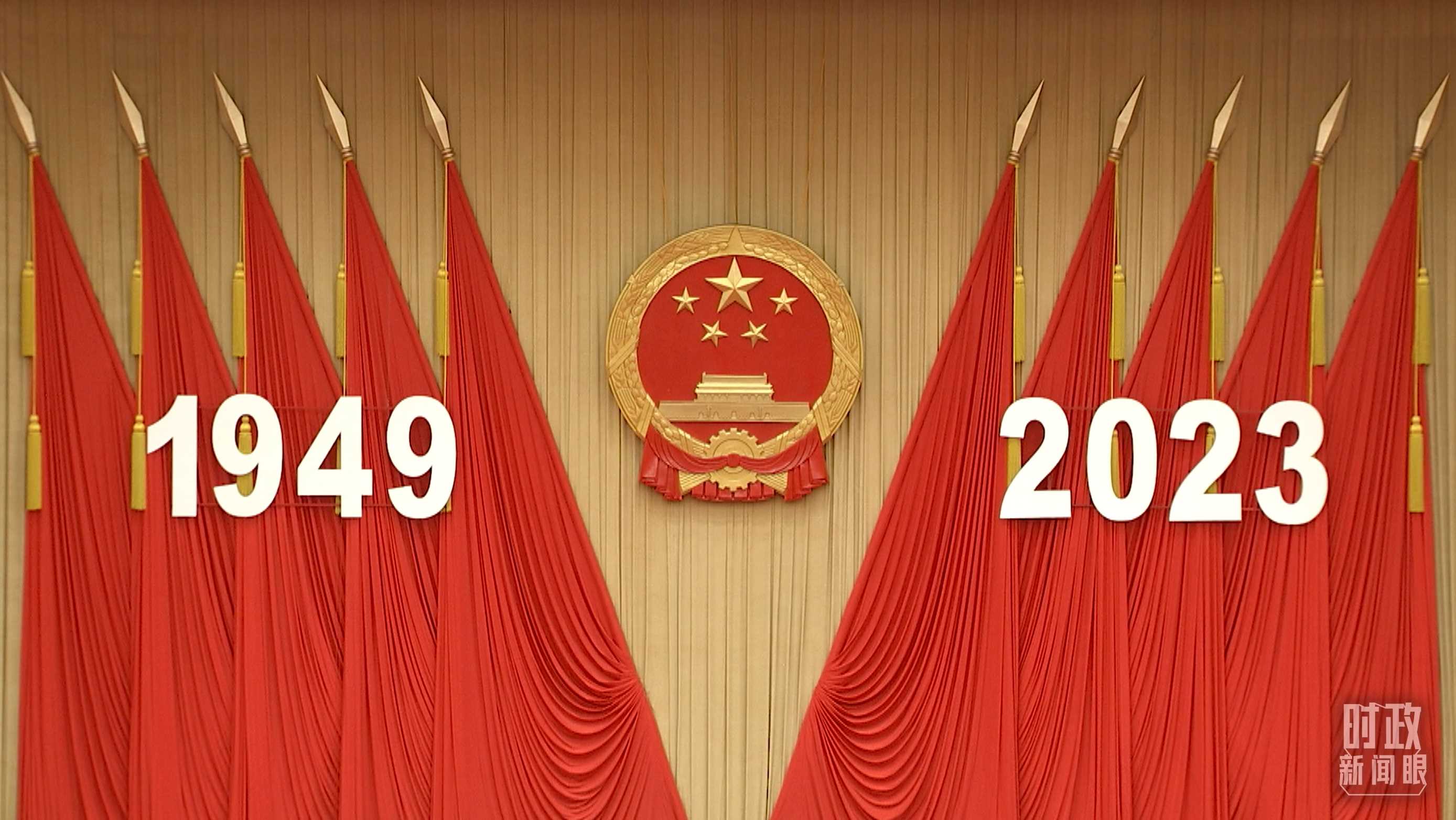 △人民大會堂宴會廳內(nèi)，主席臺上方高懸著莊嚴(yán)的國徽，“1949－2023”大字年號在鮮艷的紅旗映襯下格外醒目。