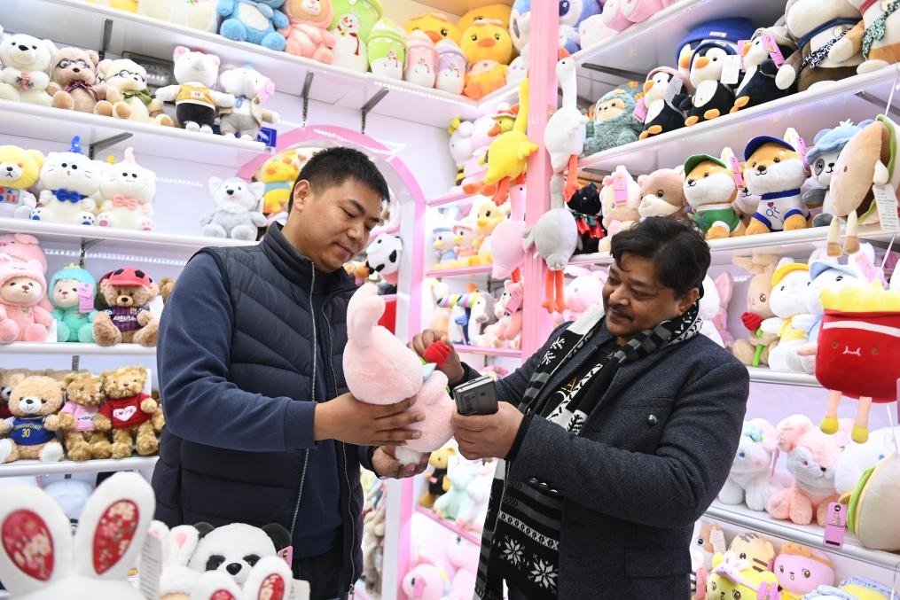 2023年2月2日，來自印度的客商（右）在義烏國際商貿城的一家玩具店鋪內選購商品。新華社記者 黃宗治 攝