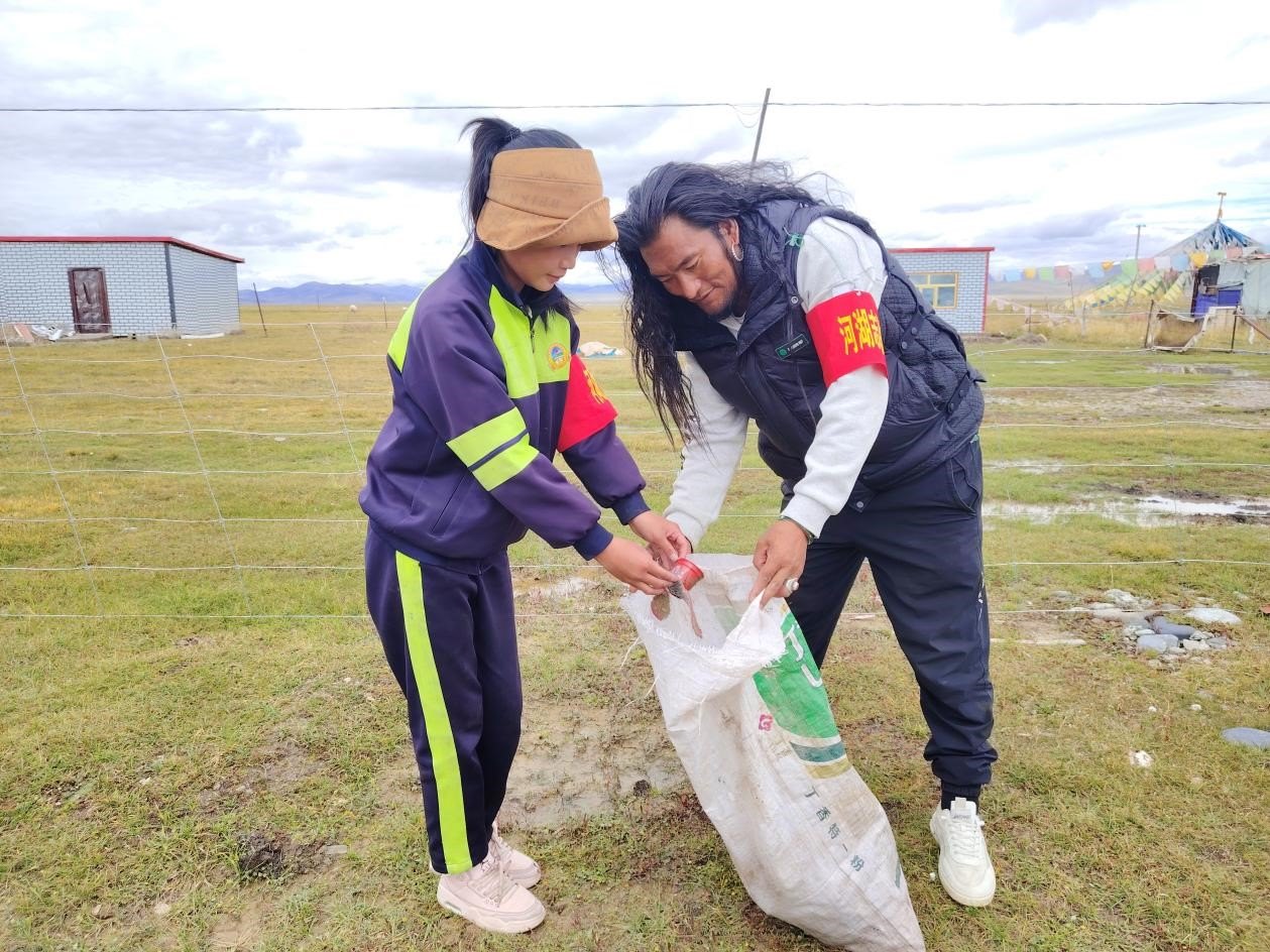玉樹州稱多縣珍秦鎮(zhèn)河湖志愿者才培和他女兒更求拉毛在清掃垃圾。受訪者供圖