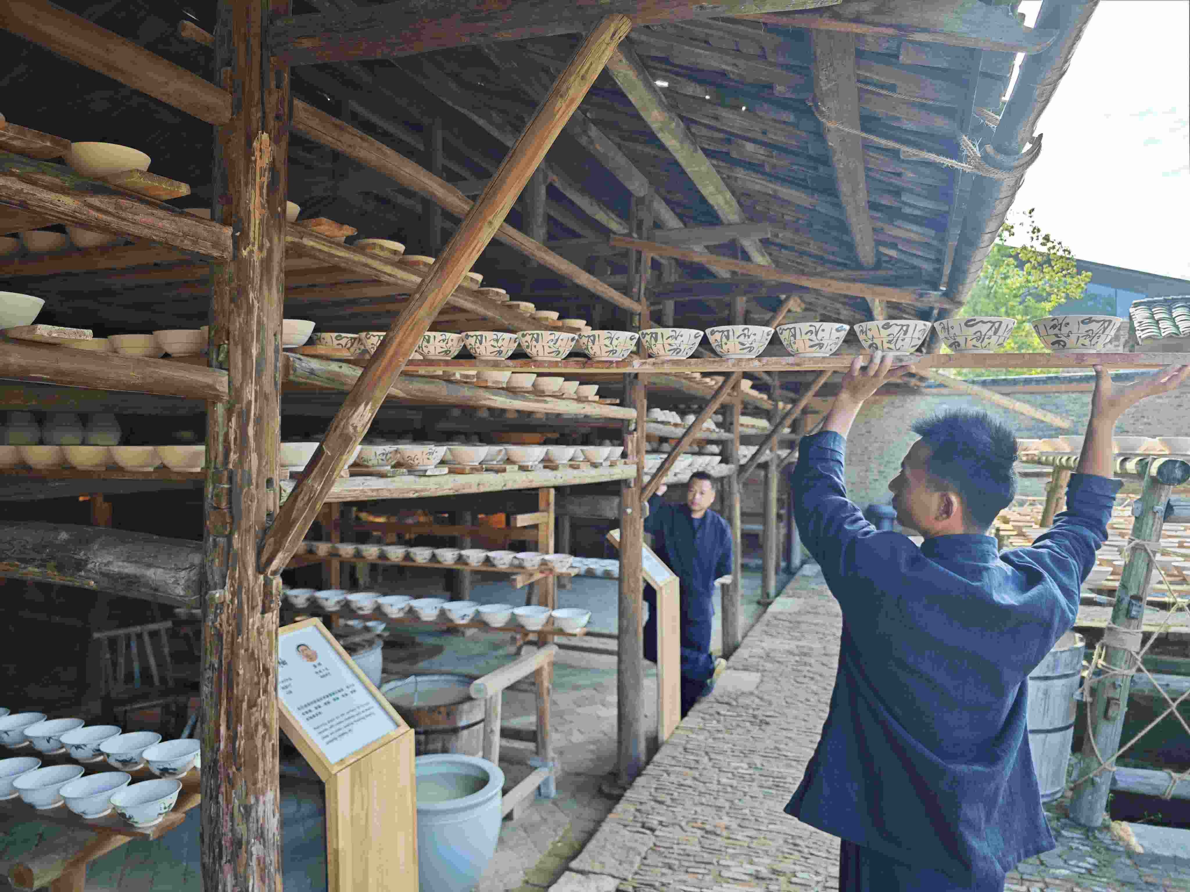 △陶陽(yáng)里歷史文化街區(qū)里，工匠將陶瓷工藝品放到架上晾干。（總臺(tái)央視記者彭漢明拍攝）
