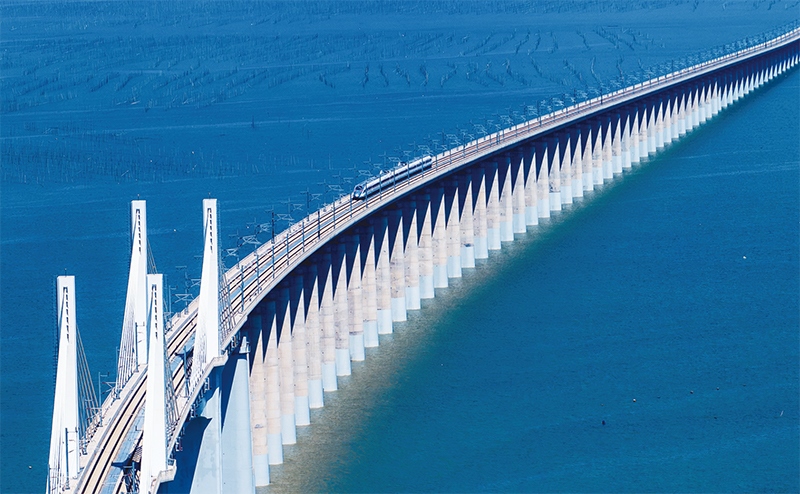 2023年9月28日，中國首條時速350公里跨海高鐵——福廈高鐵正式開通運營。圖為一列運行試驗車組駛過福廈高鐵湄洲灣跨海大橋（9月19日攝，無人機照片）。 新華社記者 魏培全/攝