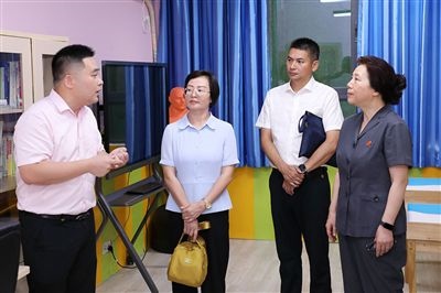圖③：“小公民法律課堂”開講前，全國人大代表殷其龍（右二）、重慶市人大代表李自玲（左二）聽取楊家坪中學(xué)負(fù)責(zé)人關(guān)于未成年人思想教育工作情況的介紹。