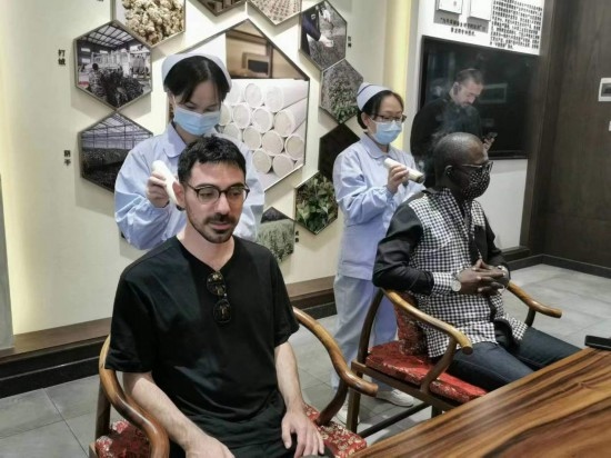 2023“一帶一路”媒體合作論壇聯(lián)合采訪團(tuán)團(tuán)員在九牛草展示館體驗艾灸。（本報記者 黃超攝）