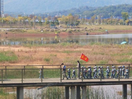 10月24日，秋游的幼兒園小朋友在老師帶領(lǐng)下走在清水塘公園里的木橋上。本報記者 常雯宜攝
