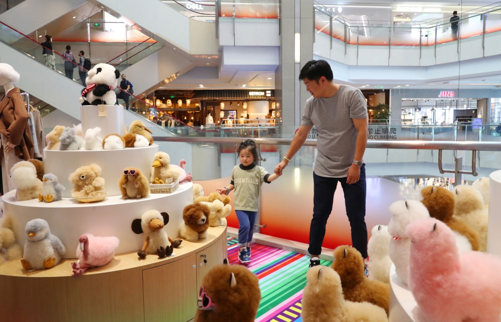 2023年11月2日，顧客在溫暖駝品牌專柜內(nèi)選購。連續(xù)六年參加進(jìn)博會(huì)的秘魯羊駝制品品牌溫暖駝在上海市中心商場開設(shè)了專柜。新華社記者 方喆 攝