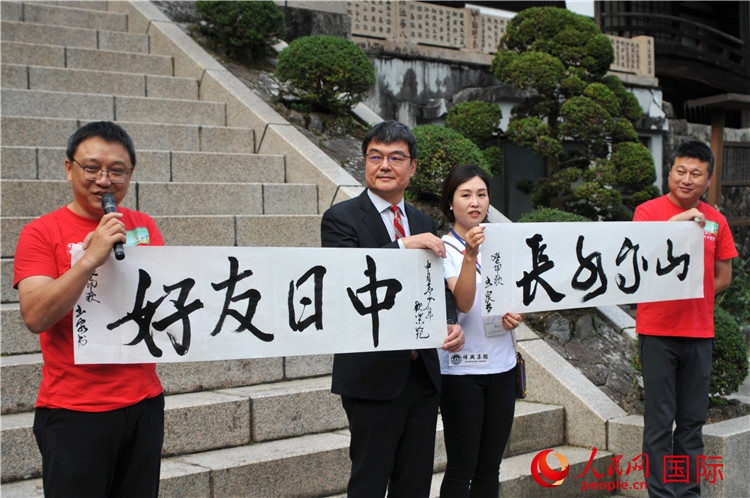 東京中國文化中心主任羅玉泉展示其為本次活動書寫的題詞“中日友好，山高水長”。人民網(wǎng) 蔣曉辰攝