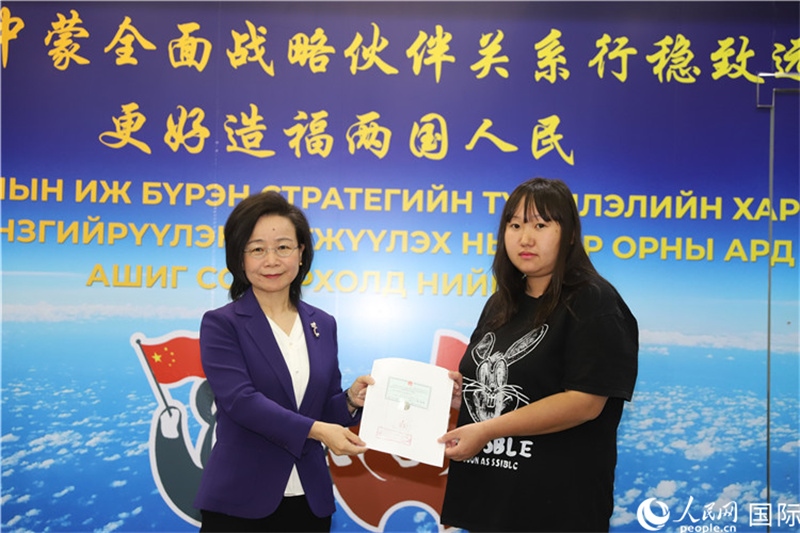 11月10日，沈敏娟大使向蒙古國公民尼亞姆庫（右）頒發(fā)最后一份領事認證書。人民網(wǎng)記者 霍文攝