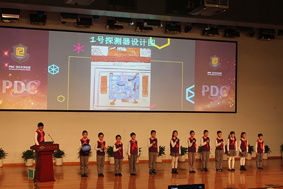 北京呼家樓中心小學(xué)的學(xué)生們展示PDC項(xiàng)目“新行星移民計(jì)劃探索衛(wèi)星設(shè)計(jì)”。