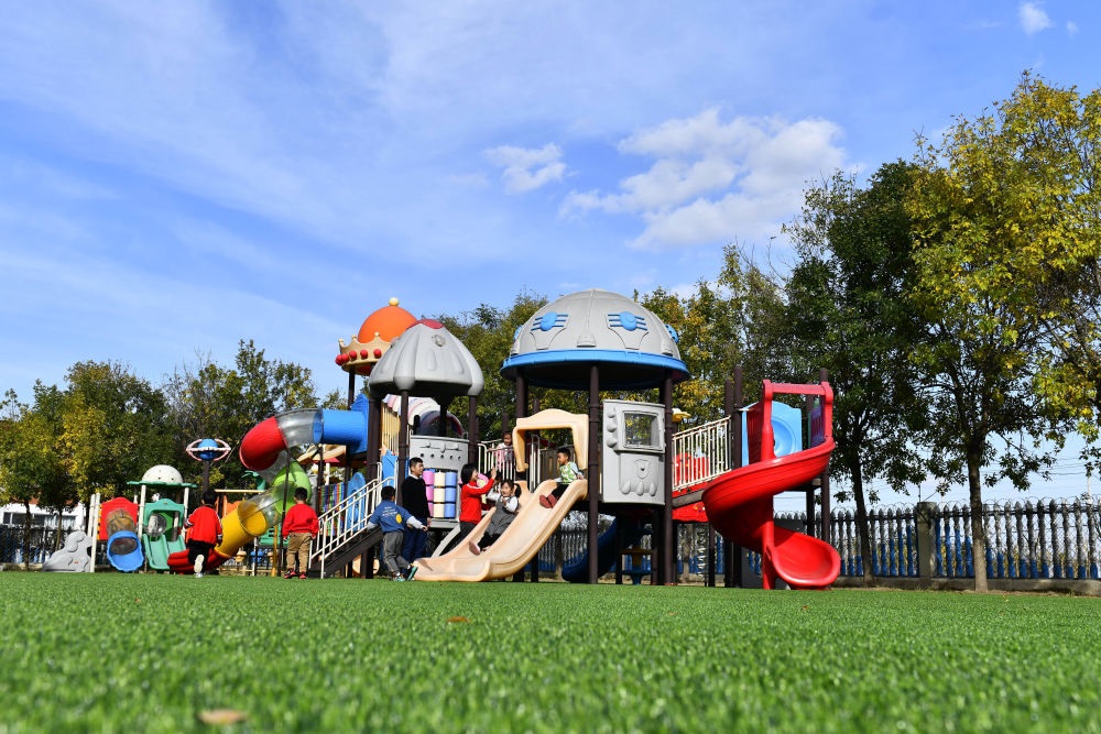 在山東省東營市墾利區(qū)楊廟社區(qū)幼兒園，孩子們在老師的帶領下進行戶外活動（2021年10月19日攝）。新華社記者 郭緒雷 攝