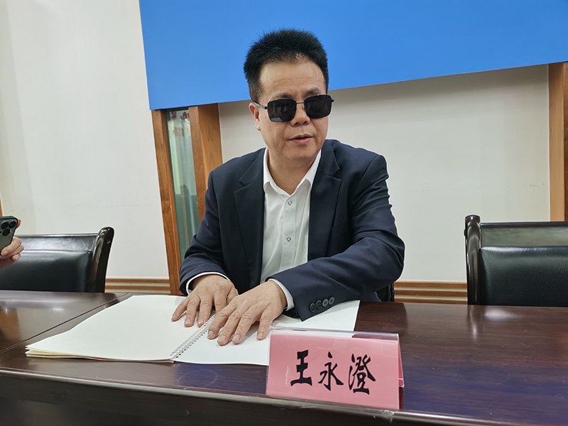 全國人大代表王永澄正在閱讀盲文版代表建議答復。本報記者 張 璁攝