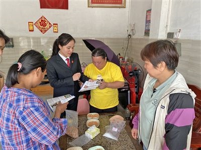  圖⑤：龍圩區(qū)法院法官到群眾家中開展法治宣傳。資料圖片